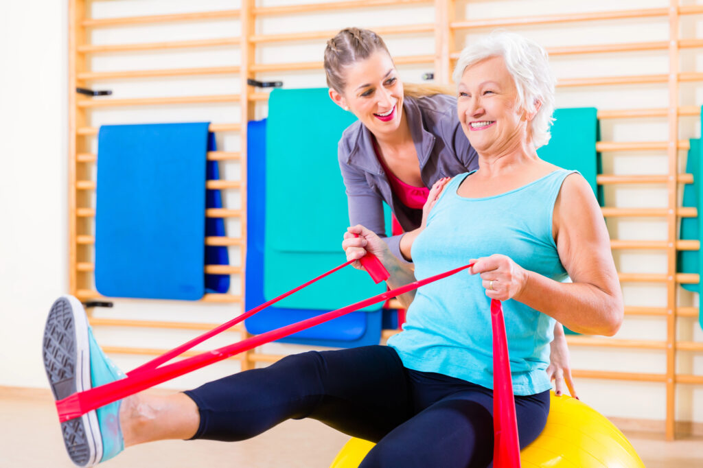 Senior woman with stretch band at fitness 